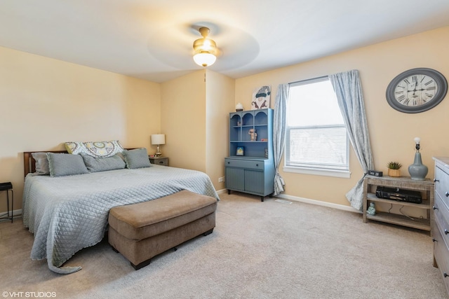 bedroom with light carpet, ceiling fan, and baseboards