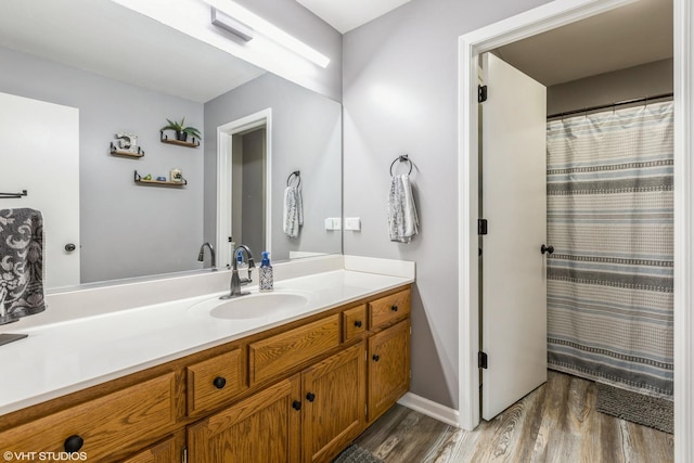 bathroom featuring baseboards, a shower with curtain, wood finished floors, and vanity