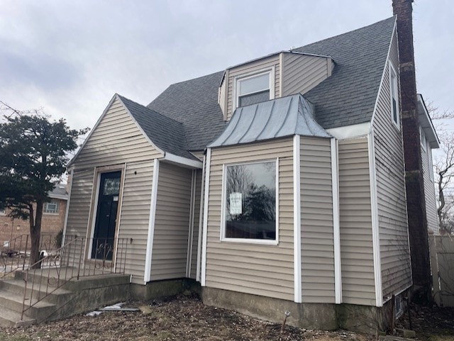 view of front of home with a shingled roof, a standing seam roof, and metal roof