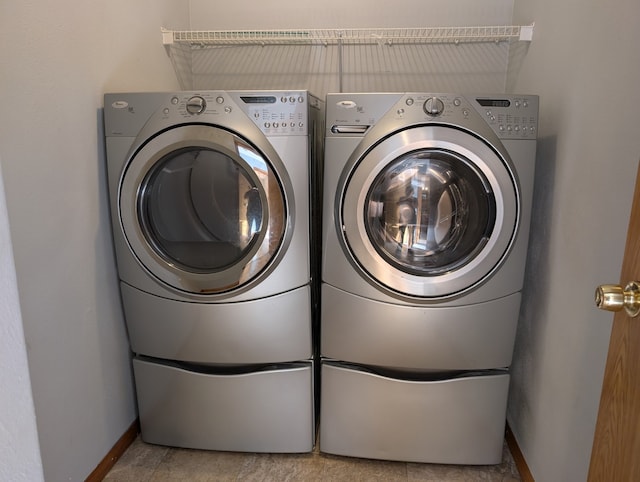 laundry area with baseboards, laundry area, and washer and dryer