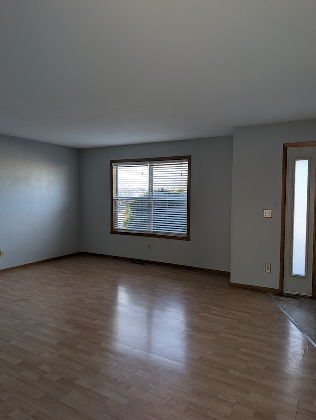 empty room featuring wood finished floors and baseboards