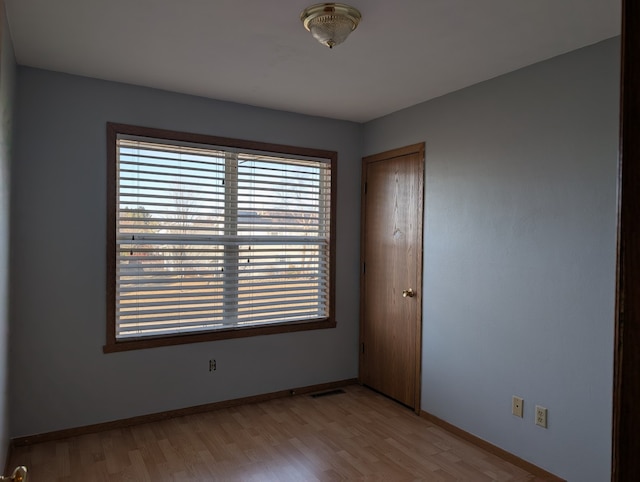 unfurnished room featuring light wood finished floors and baseboards