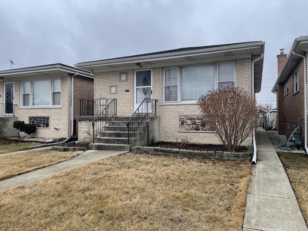 view of front of house with a front yard and brick siding