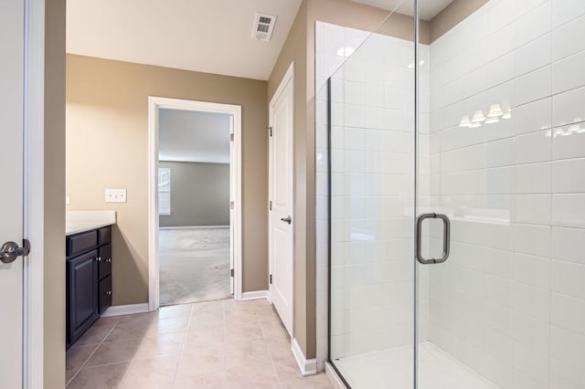 bathroom with tile patterned flooring, vanity, visible vents, baseboards, and a shower stall