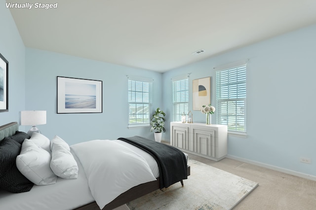 bedroom featuring light colored carpet, visible vents, and baseboards