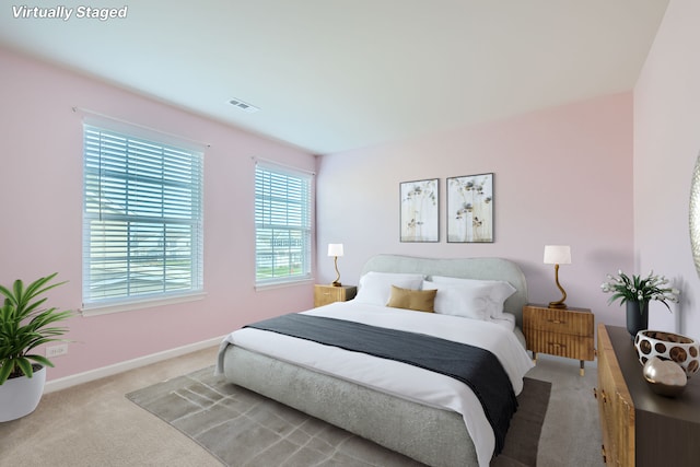 bedroom featuring baseboards, visible vents, and light colored carpet