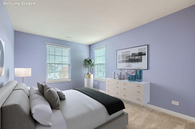 bedroom featuring light carpet, visible vents, and baseboards