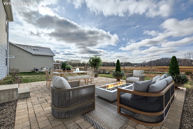 view of patio / terrace featuring central air condition unit and an outdoor living space with a fire pit