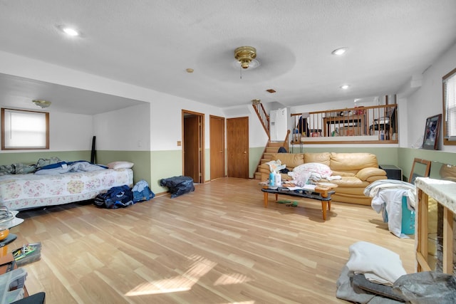 bedroom with recessed lighting, a textured ceiling, and wood finished floors