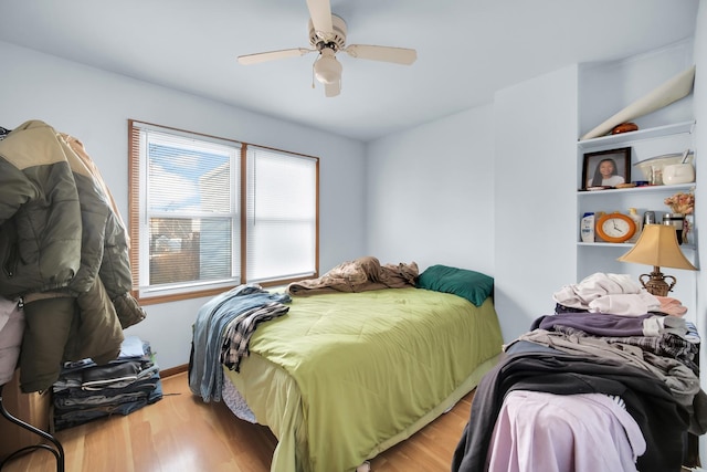 bedroom with baseboards, a ceiling fan, and wood finished floors