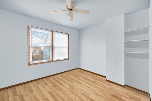 spare room with a ceiling fan, light wood-style flooring, and baseboards