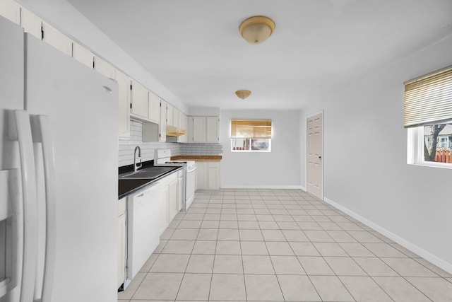 kitchen featuring white appliances, plenty of natural light, a sink, and tasteful backsplash