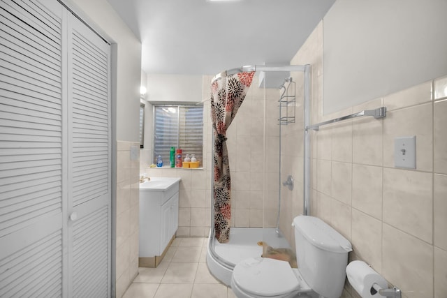 full bathroom featuring tile walls, a closet, toilet, a stall shower, and tile patterned flooring