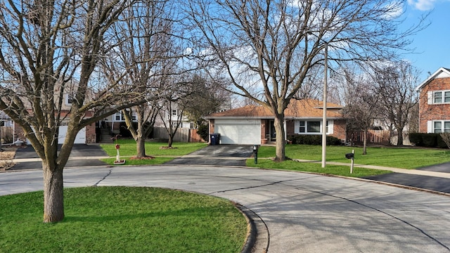 view of front of house featuring brick siding, an attached garage, fence, driveway, and a front lawn