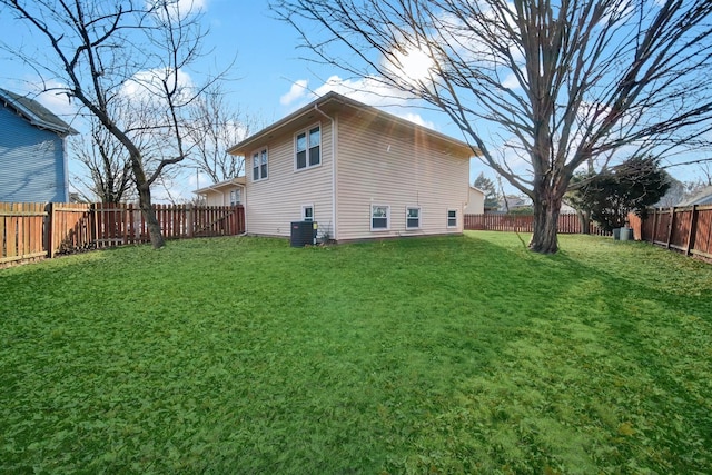 exterior space with central AC, a lawn, and a fenced backyard