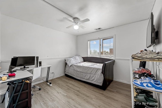 bedroom featuring light wood-type flooring, visible vents, ceiling fan, and baseboards