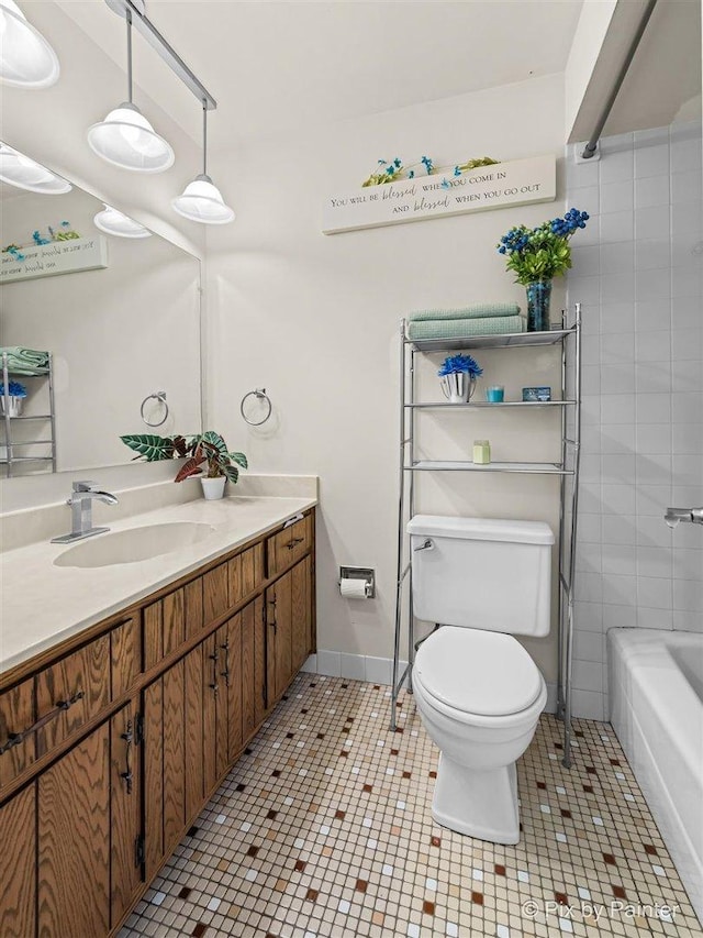 bathroom with baseboards, vanity, toilet, and tile patterned floors