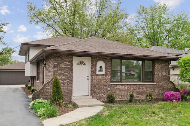 14951 Kilbourne Ave, Midlothian, IL 60445 - view of front of home featuring brick siding, a shingled roof, a detached garage, and an outbuilding