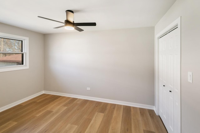 unfurnished bedroom with light wood-type flooring, a ceiling fan, baseboards, and a closet