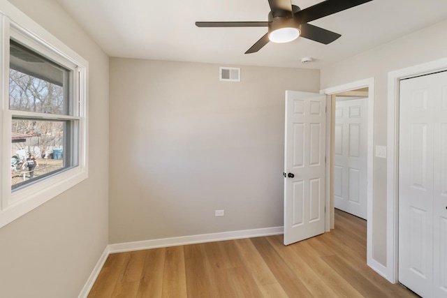 unfurnished bedroom featuring light wood finished floors, a closet, visible vents, and baseboards