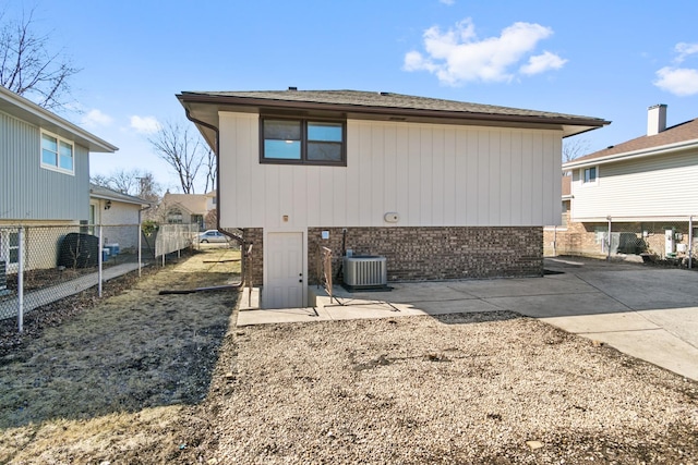 rear view of property with central AC, brick siding, a patio, and fence