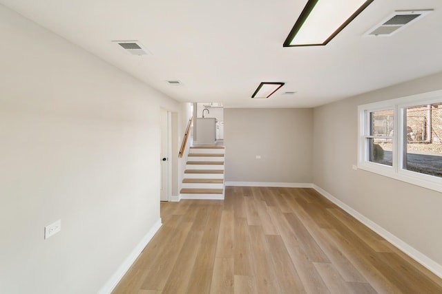 interior space with light wood finished floors, stairway, visible vents, and baseboards