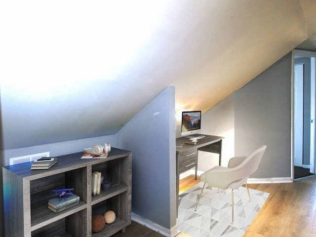 office area featuring baseboards, vaulted ceiling, and wood finished floors