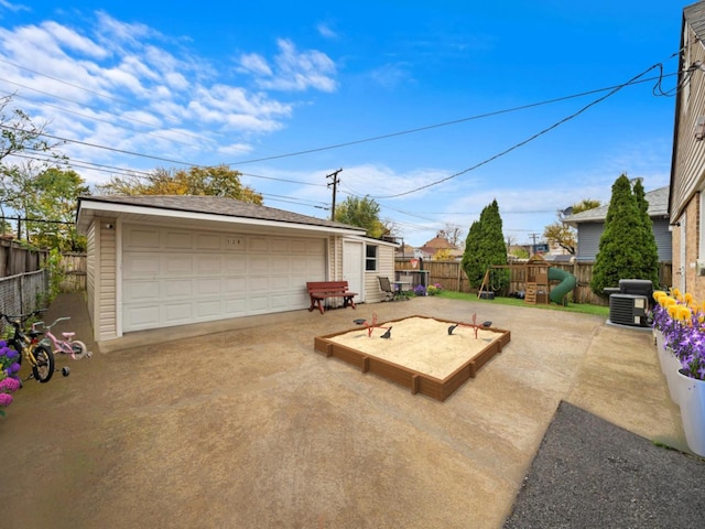 exterior space with a detached garage, fence, and an outbuilding