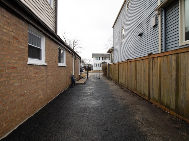 view of side of property featuring brick siding and fence