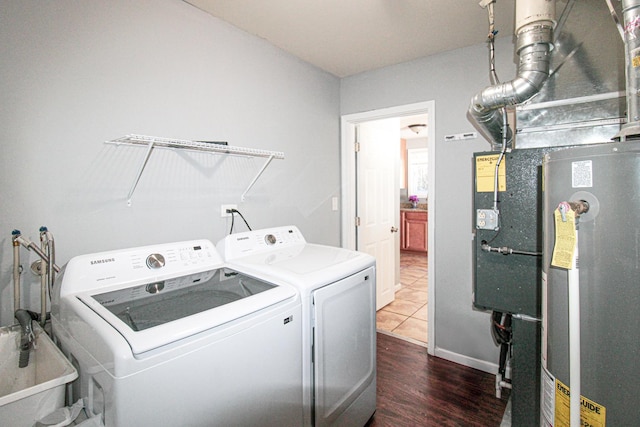 clothes washing area with laundry area, a sink, baseboards, washer and clothes dryer, and dark wood finished floors