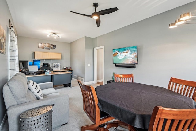 dining space with a ceiling fan, visible vents, light colored carpet, and baseboards