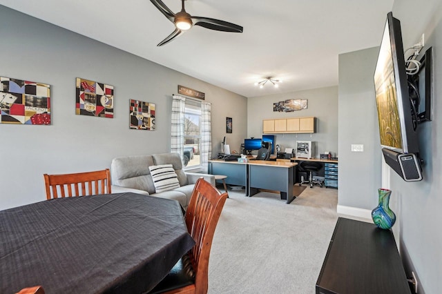 dining room with light carpet, baseboards, and a ceiling fan