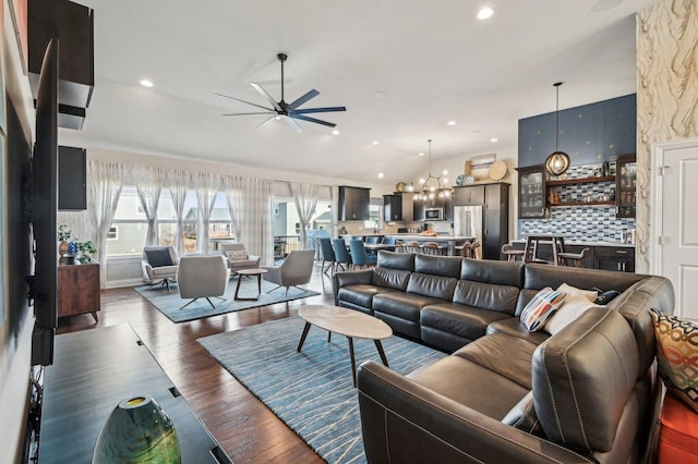 living area with recessed lighting, a ceiling fan, dark wood-style flooring, and vaulted ceiling