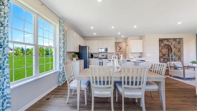 dining space with baseboards, wood finished floors, visible vents, and recessed lighting