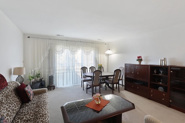 living area with visible vents and carpet