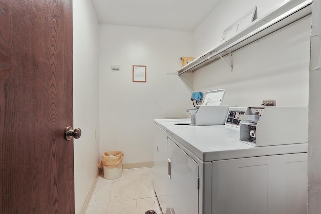 shared laundry area with light tile patterned floors, baseboards, and separate washer and dryer