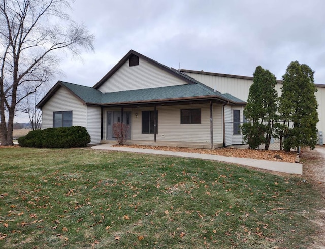 view of front of property with a shingled roof and a front yard