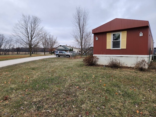 view of side of property featuring central AC and a lawn