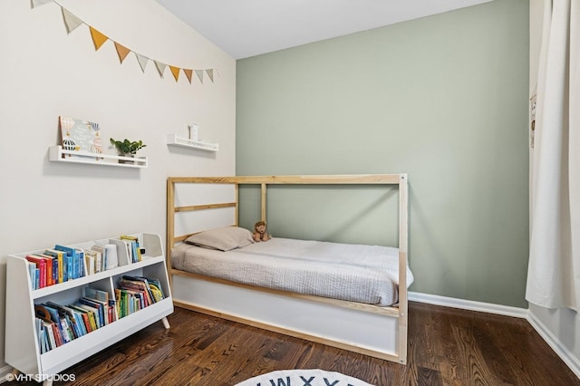 bedroom with baseboards and wood finished floors