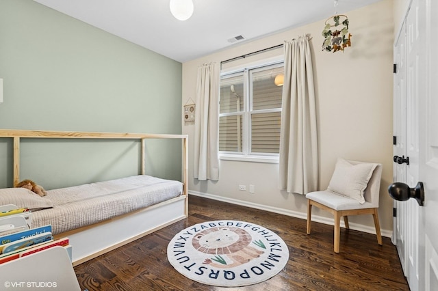 bedroom featuring visible vents, baseboards, and wood finished floors