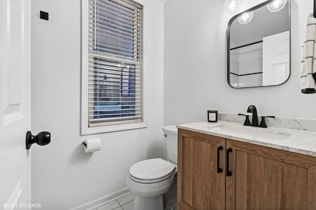 bathroom with baseboards, vanity, toilet, and tile patterned floors