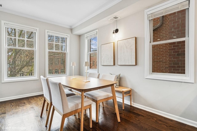 dining space with visible vents, baseboards, wood finished floors, and ornamental molding