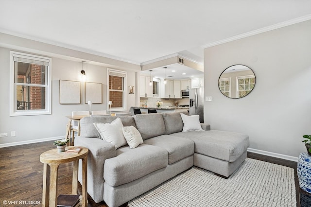 living area with baseboards, wood finished floors, and ornamental molding