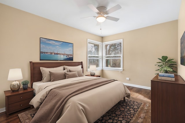 bedroom featuring baseboards, dark wood finished floors, and a ceiling fan