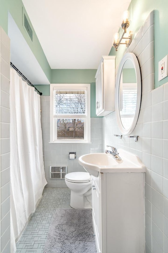 bathroom with visible vents, toilet, tile walls, and vanity