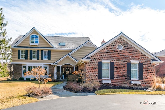 view of front of property featuring brick siding and a front lawn