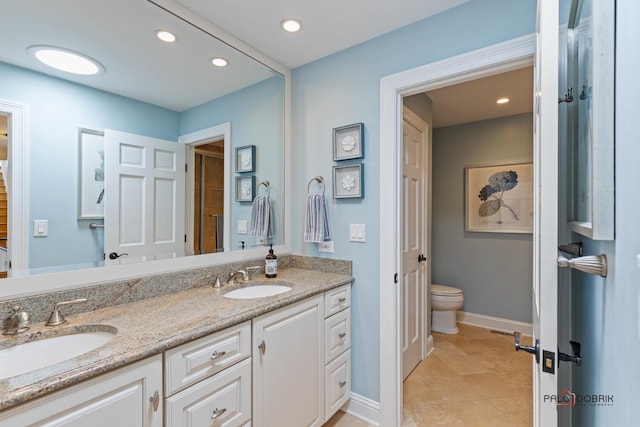 full bathroom featuring double vanity, recessed lighting, baseboards, and a sink