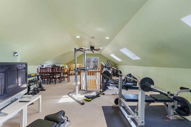 exercise area with vaulted ceiling with skylight, carpet, and ceiling fan