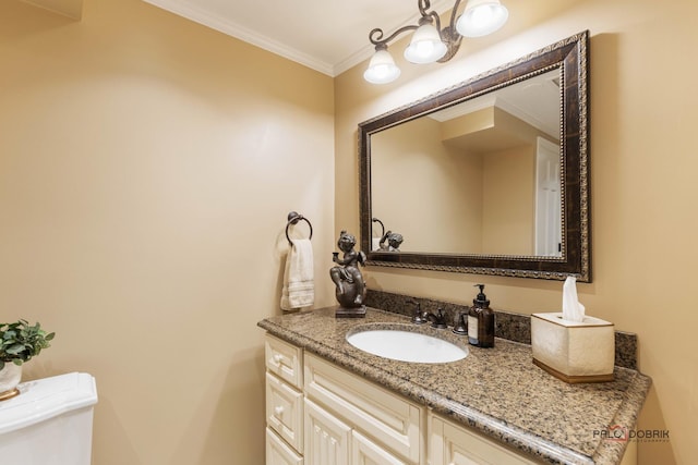 half bath featuring toilet, vanity, and crown molding