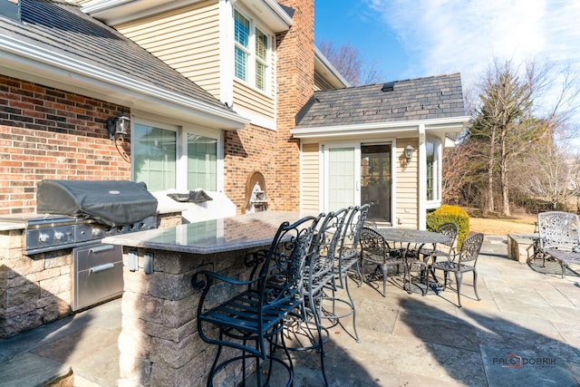 view of patio / terrace featuring outdoor dining area, area for grilling, and outdoor dry bar